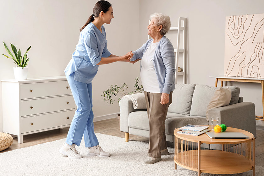 Physical therapist helping senior woman to walk